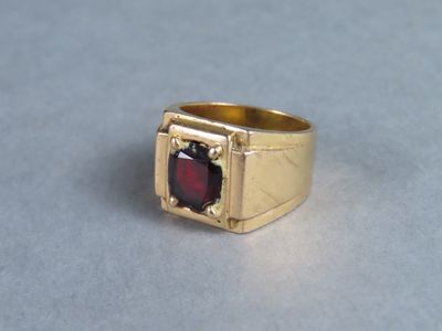 une image représentant une bague en or sertie d'une grenat