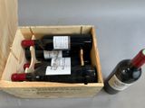 two bottles of wine in a wooden box next to a bottle of wine