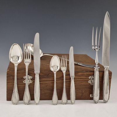 une boîte en bois sur laquelle est posé un ensemble d'argenterie