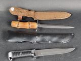 several knives are lined up on a table with a knife in the middle of them
