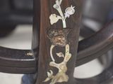 a close up of a wooden chair with a floral design on it