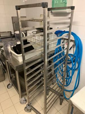une étagère métallique sur laquelle sont posés plusieurs plateaux, dans une cuisine