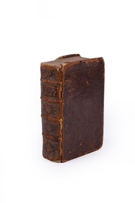 un vieux livre est posé sur une surface blanche avec un fond blanc