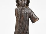 une statue en bronze représentant un enfant vêtu d'une robe