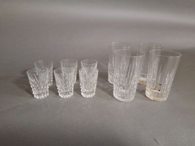 quatre verres et une bougie sont alignés sur une table