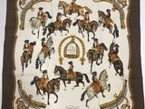 un gros plan sur un foulard carré orné de chevaux et de cavaliers
