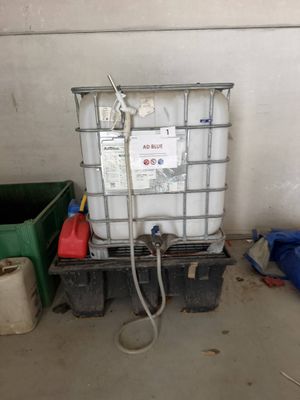 un conteneur muni d'un tuyau, placé à côté d'une poubelle
