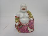 une figurine représentant un Bouddha souriant assis sur un coussin