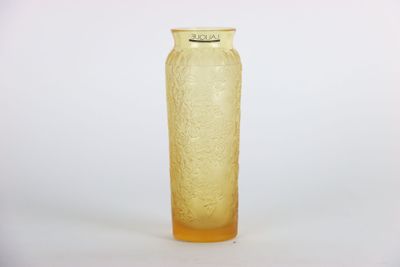 un vase jaune posé sur une surface blanche