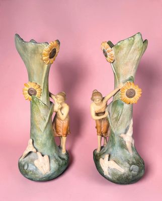 two vases that are sitting on a pink surface