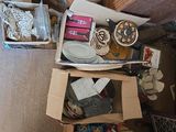boxes of assorted items sit on the floor in a cluttered room