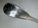 a silver spoon with a silver handle sitting on a table