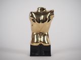 a gold statue of a torso on a black base
