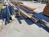 many pieces of wood sitting on the ground next to a building