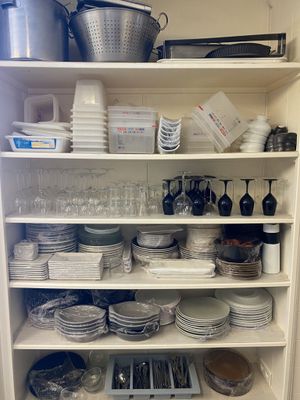 shelves filled with dishes and utensils in a kitchen