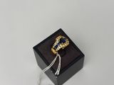 un gros plan d'une bague dans une boîte noire posée sur une surface blanche
