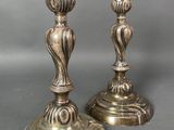 pair of antique brass candlesticks on stand on grey background