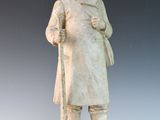 statue d'un homme portant un chapeau et un manteau, tenant une canne