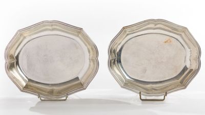 pair of silver plated dishes on stands on a white surface