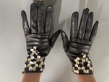 black leather gloves with gold and silver buttons on them