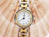 an image of a close up of a wrist watch with a shell in the background