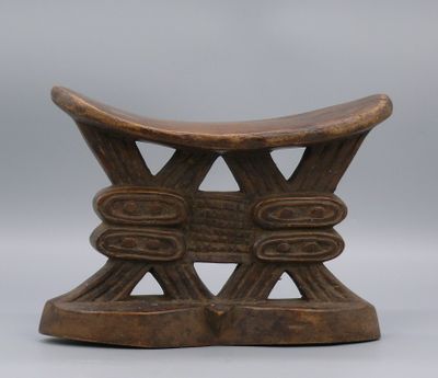 Appui-nuque en bois dur à patine sombre à l’assise incurvée …