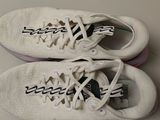 pair of white tennis shoes sitting on top of a white table