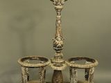 an antique silver plated candle holder with two cups on a stand