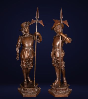 une paire de statues en bronze représentant des hommes armés de lances et de boucliers