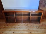 an image of a wooden entertainment center with glass doors