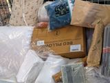a pile of bed pillows and other items in a shopping cart