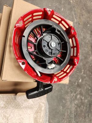 un panier rouge muni d'une poignée noire, posé sur une boîte en carton