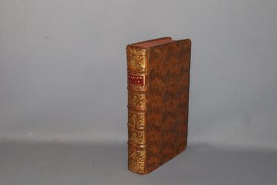 an old book sitting on top of a table next to a white wall