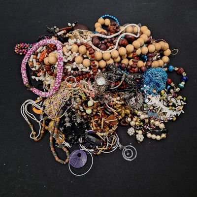 un tas de perles et de bijoux divers posés sur une surface noire