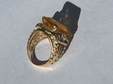 a gold ring with a stone in it sitting on a table