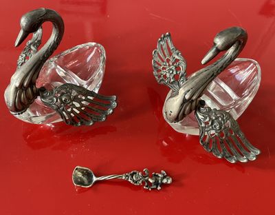 two swan figurines sitting on a red surface