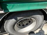 a green and yellow truck parked on the side of the road
