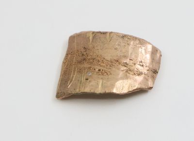 une image représentant un morceau de métal posé sur une surface blanche