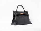 a black leather handbag on a white background
