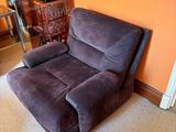 a brown recliner in a living room with orange walls