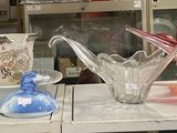 de nombreux vases en verre posés sur une étagère dans un magasin
