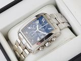 a silver watch in a box with a blue face
