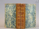 un vieux livre à la couverture bleue et jaune posé sur une table blanche