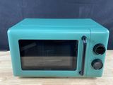 un vieux four à micro-ondes posé sur une table en bois
