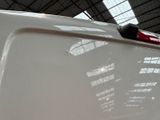 a close up of a white car with a red handle on it