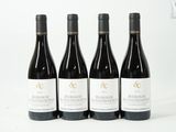 quatre bouteilles de vin sont alignées sur une surface blanche