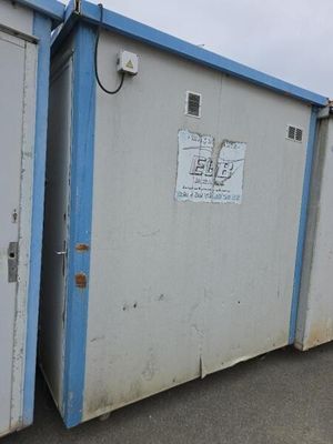 deux toilettes portables blanches et bleues dans un parking