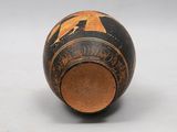 a black and orange vase sitting on a white surface