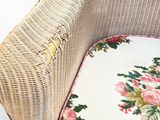 a wicker chair with a floral cushion on it