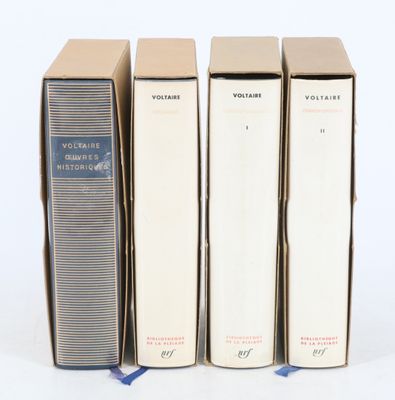 trois livres sont empilés sur une surface blanche